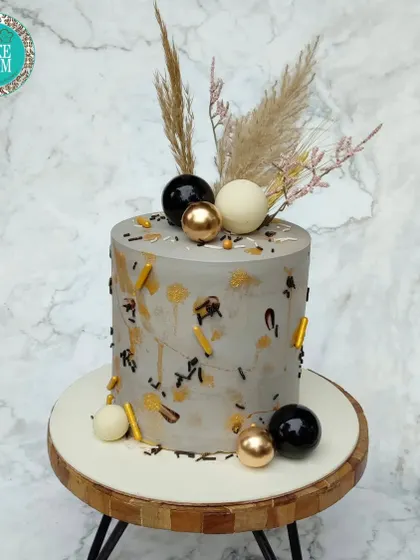 A captivating gold dust wedding masterpiece. The grey marble effect is accented with gold, black, and white spheres and dried pampas grass for a modern, elegant look.