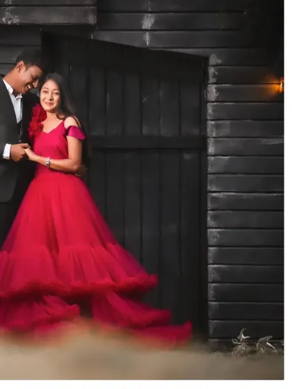 A moody and romantic pre-wedding photo taken against a dark, rustic backdrop. The use of soft smoke adds a touch of mystery and drama to the scene.