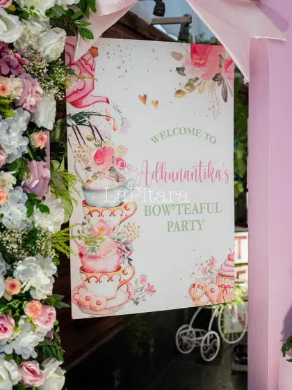 A close-up of the beautifully designed welcome sign, featuring watercolor illustrations of teacups and flowers.
