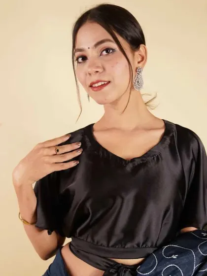 This black satin blouse with bell sleeves and a tie-waist is a modern and chic essential for any wardrobe.