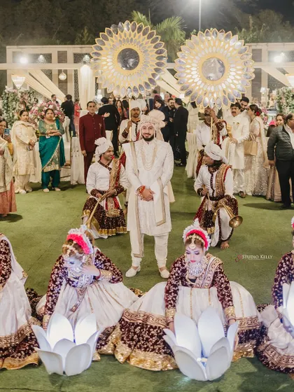 The groom's grand entry, surrounded by performers and traditional musicians.