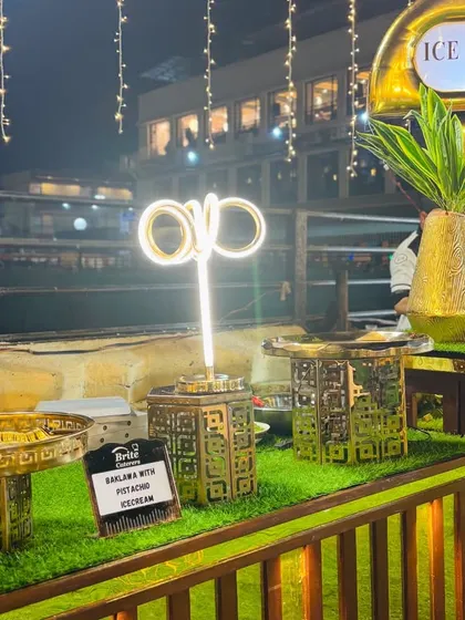 An ice cream station with ornate golden counters and modern neon lighting.