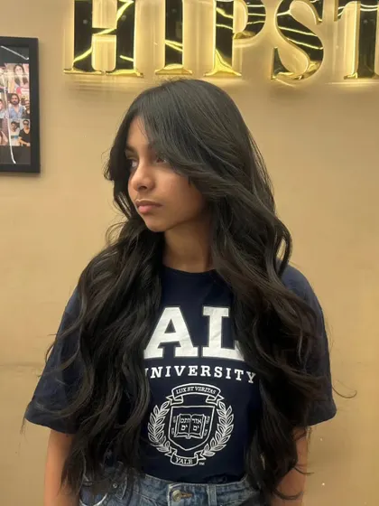 A client with a fresh haircut, featuring long layers and soft waves that boost confidence and style.