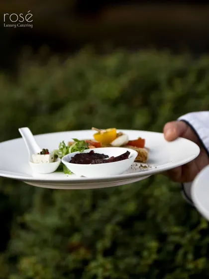 A chef holds a perfectly plated dish, ready to be served. This image captures our focus on creating culinary experiences beyond compare, with attention to every detail.