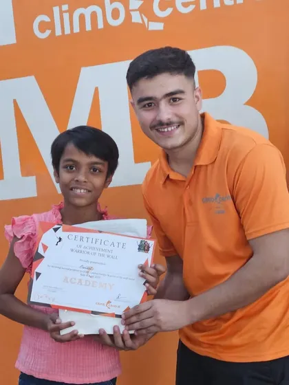 A proud moment as a young winner receives her certificate and prize at the 'Warrior of the Wall' competition. It's all about celebrating effort and achievement.