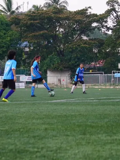 A player controls the ball in the midfield during a heated match at the Bangalore Football Stadium.