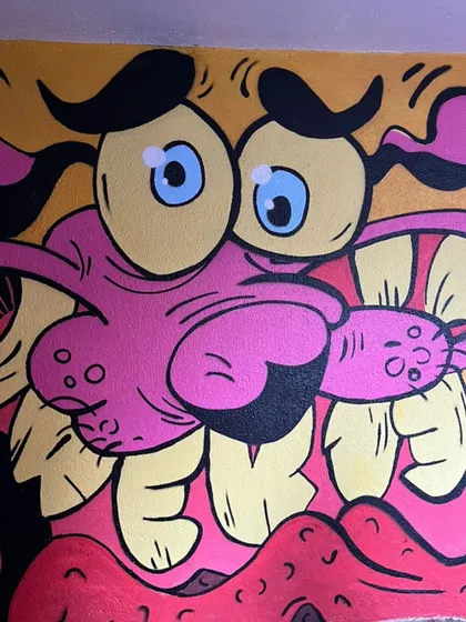 The finished Courage the Cowardly Dog mural, ready for the graffiti battle. The vibrant pinks and yellows really make it pop.