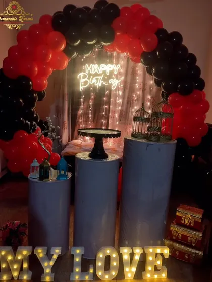 A romantic red and black balloon arch with a 'Happy Birthday' neon sign and 'My Love' marquee letters, perfect for a surprise celebration.
