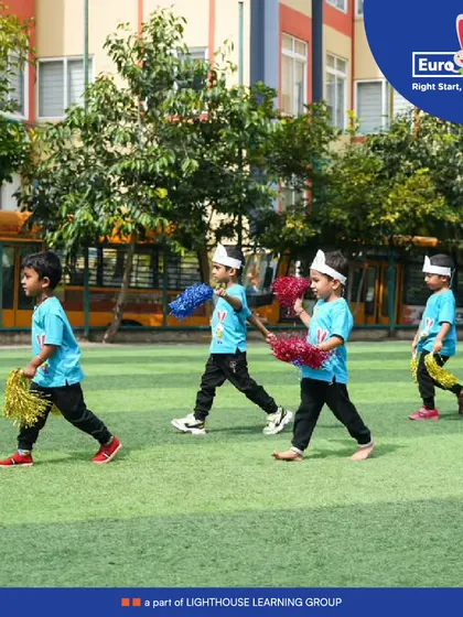 Marching with pride. Little cheerleaders with pom-poms parade across the field, showing their team spirit and adding to the festive atmosphere of our sports day.