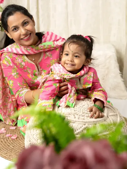 A mother and daughter share a sweet, smiling moment during their traditional-themed photoshoot.
