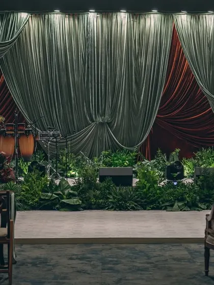 A stage set for a sangeet inspired by the dramatic artistry of Raja Ravi Varma. We used deep, contrasting velvets and lush foliage instead of extensive florals to create a moody, theatrical ambiance that feels like stepping into a timeless painting.