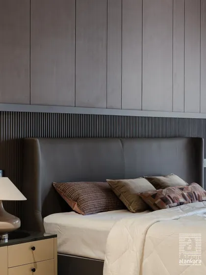 This modern bedroom design features a sophisticated winged headboard in dark leatherette, set against a backdrop of fluted and flat wall panels. The textures and tones combine to create a space that is both masculine and luxurious.