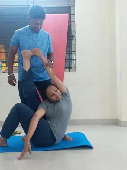 Hands-on adjustments are a key part of my teaching. Here, I am helping a student find the correct alignment in a seated twist. This personal guidance ensures you practice safely, understand the posture deeply, and get the most out of every movement.