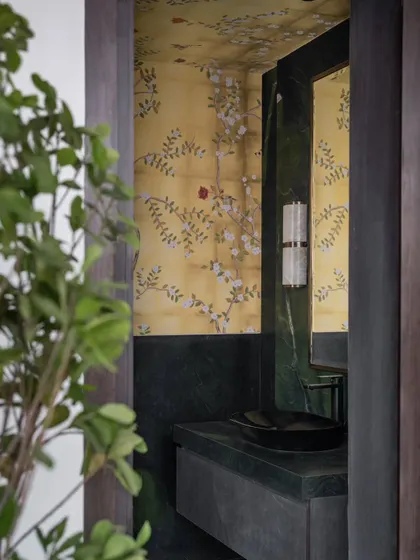 A jewel-box powder room in Hyderabad. We paired rich avocado green marble with delicate hand-painted walls and soft alabaster sconces to create a small space that is full of drama and impact.
