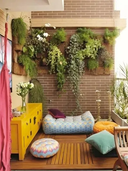 A vibrant and eclectic balcony with a colorful floor cushion, a bright yellow cabinet, and a lush vertical garden. This design is full of personality and perfect for casual lounging.