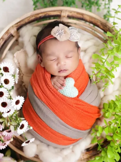 A close-up showing the baby holding a small crocheted heart. It's these tiny, thoughtful details that make our newborn photography sessions so special and personalized.