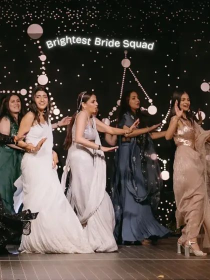 The bride squad, dressed in shimmering sarees and lehengas, performs a choreographed dance on stage, perfectly embodying the 'Brightest Bride Squad' energy of the cosmos-themed Sangeet.