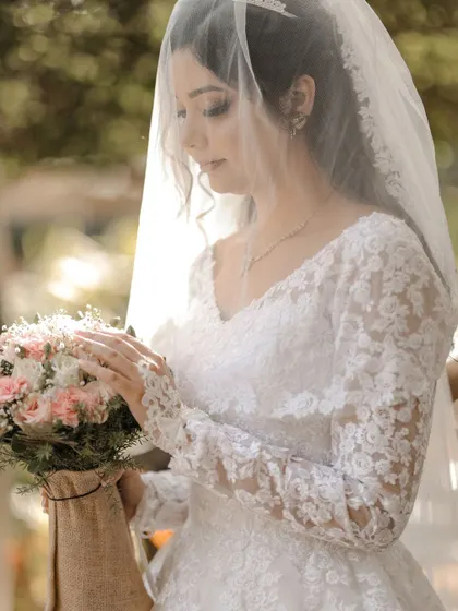 A delicate portrait of the bride looking at her bouquet, with the veil creating a soft focus.