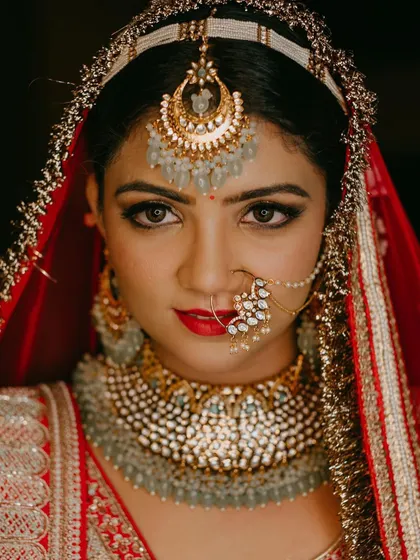 For the classic bride who dreams of a grand entrance, a bold red lip and defined eyes are timeless. This close-up shows how I balance a strong lip with radiant skin and shimmering gold eyeshadow for a truly regal North Indian bridal look.