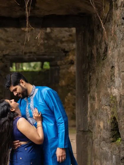 A romantic pre-wedding shot of a couple gazing into each other's eyes inside the archway of an old fort, creating a sense of timeless love.