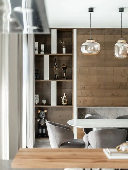 Inside the Silhouette home, the design ethos of connection continues. This dining area features warm wood paneling and curated art, creating a sophisticated space for family gatherings that feels both modern and inviting.