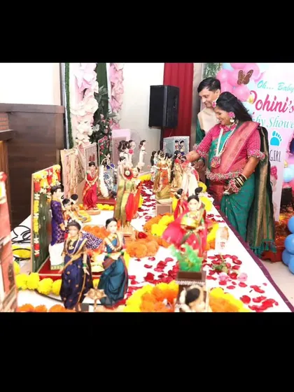 A lovely couple admiring the intricate details of their baby shower rukhwat, a centerpiece of their celebration.