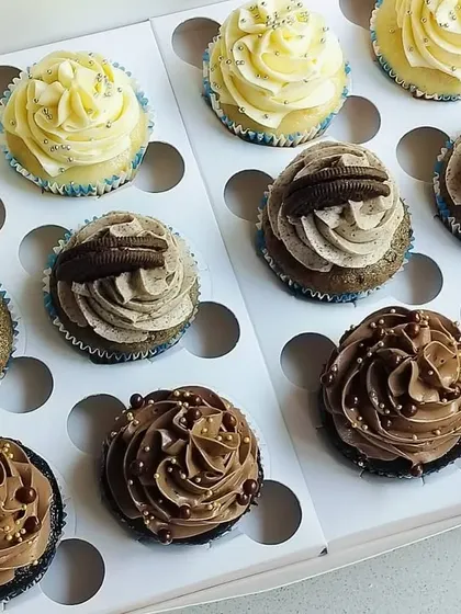 A closer look at the box of 12 classic cupcakes, showing the different frosting styles for the Chocolate, Vanilla, and Oreo flavors.