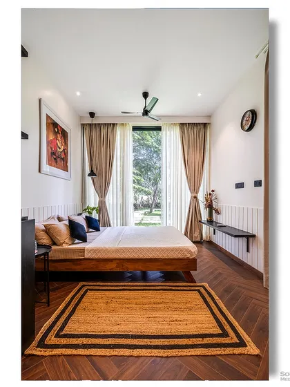 A bedroom in a prefab home with a large window that opens up to a garden view. The simple, clean design and natural materials make this a peaceful and relaxing retreat.