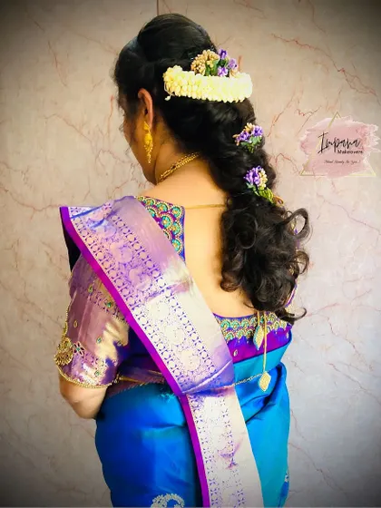The back view of a beautiful party hairstyle. This half-up look with soft curls is elegant and perfect for any special occasion.