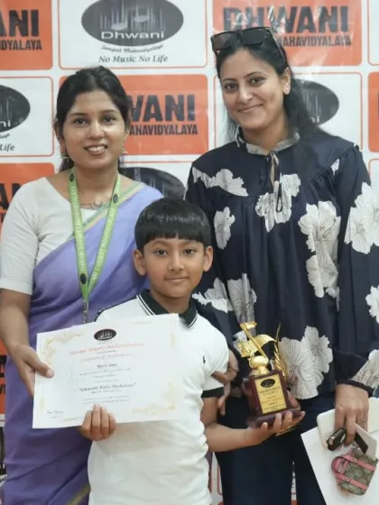 A student receives his award from a faculty member. The prize distribution ceremony is a formal recognition of the talent nurtured at Dhwani.
