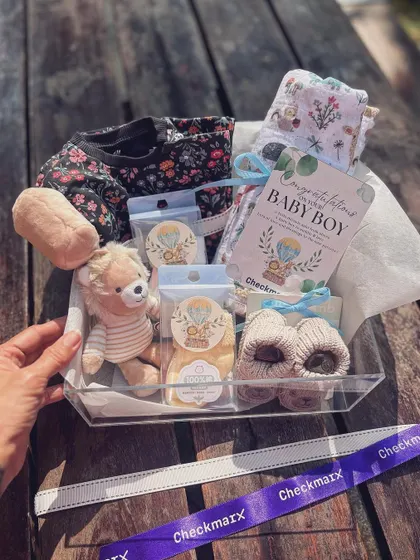 A look inside the clear acrylic hamper, showing how I arrange each item, like the floral-print onesie and lion rattle, to create a beautiful and cohesive collection.