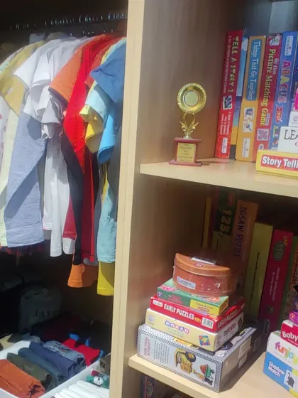 This child's wardrobe combines hanging space for shirts with shelves for games and puzzles. Keeping their favorite activities visible and accessible encourages both play and tidiness.