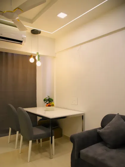 Another view of the compact dining setup, highlighting the modern pendant lights that add a touch of contemporary flair.