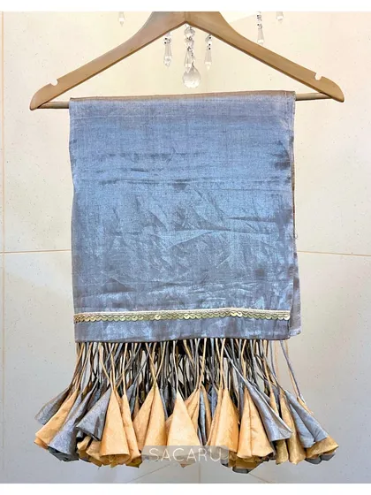 The saree's dramatic tassels on full display, showing the beautiful craftsmanship of the gold and silver fabric cones.