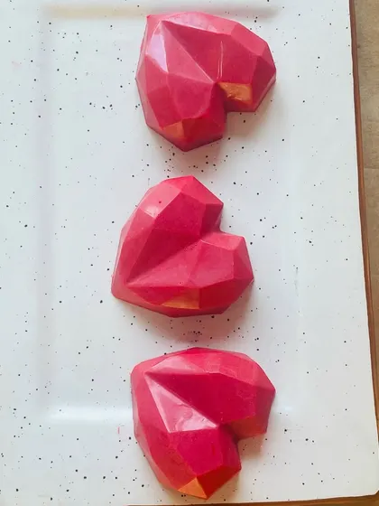 Our mini geometric heart-shaped cakes are a perfect small bite. These are filled with rich chocolate cake and covered in a colored chocolate shell.