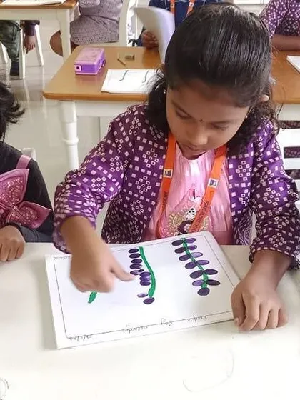 Students use their fingers to paint purple flowers, a tactile and fun art activity for Purple Day.