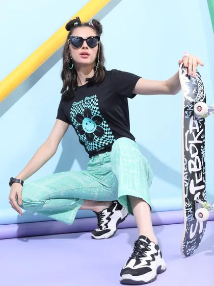 A skater-girl aesthetic I styled for a Myntra shoot. The look pairs a graphic tee with mint green pants and chunky sneakers, accessorized with a skateboard for an authentic feel.