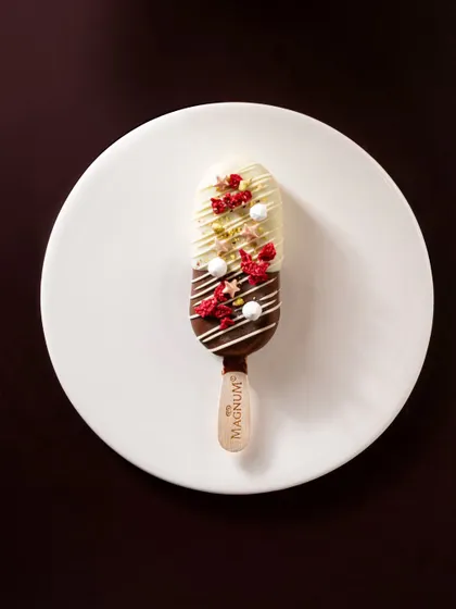 A clean and simple shot of a dual-toned Magnum bar, focusing entirely on the product itself against a plain white plate.