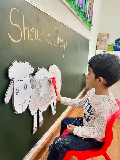 A student carefully removes the last bit of "wool." Our farm-themed activities are designed to be engaging and educational, bringing concepts from books into the real world.