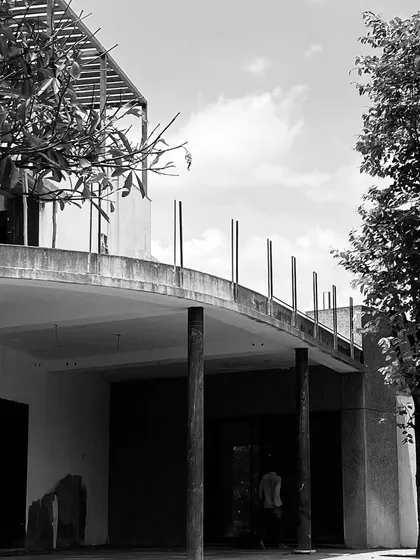 Ridge House in progress, with its curved concrete facade and columns in place. This black and white shot emphasizes the home's strong, modern form against the sky.