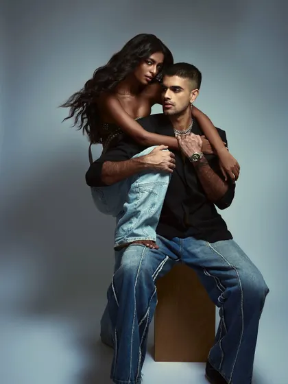 A full-body couples shot with a fashion-forward pose.