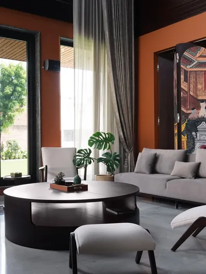 Natural light was key in this space. The large windows and sheer curtains soften the formal setting, connecting the rich interiors with the green garden outside and creating a serene, airy atmosphere during the day.