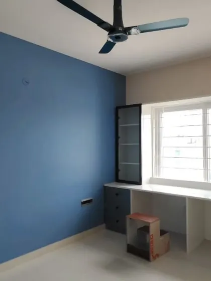 A serene bedroom featuring a calming blue accent wall paired with a neutral off-white. This space also includes a custom-built study nook, where we painted the desk and cabinetry to match the room's modern aesthetic.