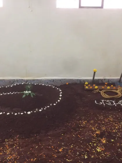 The 'lal mati' pit decorated for the inauguration puja. The tools used to maintain the pit are also blessed, honoring every aspect of our tradition.