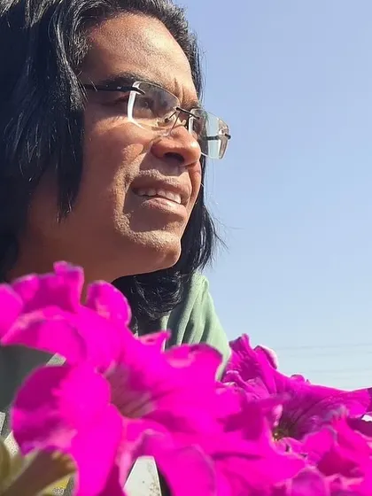 Taking a moment to enjoy the vibrant colors of a petunia flower bed I designed. Being close to nature and the flowers I plant is the best part of my job.