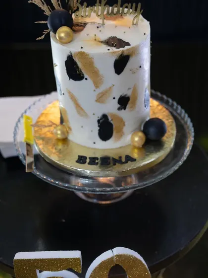 A chic and modern cake for a 50th birthday. The black and gold brushstroke design perfectly matched the party's elegant theme, proving that the cake can be a work of art.