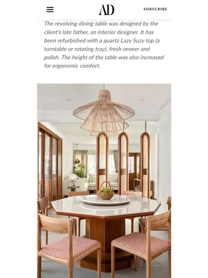 An article clipping from Architectural Digest describing the revolving dining table's history and refurbishment. The height was increased for ergonomic comfort, blending family heritage with modern usability.