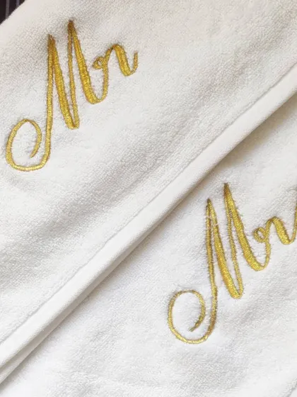 It's all in the details! This is a close-up of my classic 'Mr & Mrs' embroidery in a stunning gold thread on premium white towels. This elegant cursive font is my most requested style for wedding and anniversary gifts.