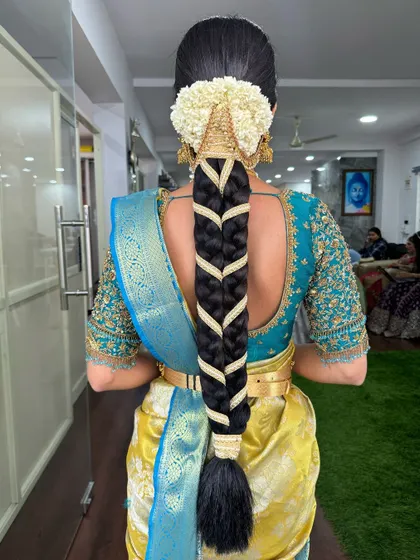 A classic fishtail braid woven with a gold ribbon, finished with a traditional jasmine gajra. This hairstyle is both elegant and secure for a long day of festivities.