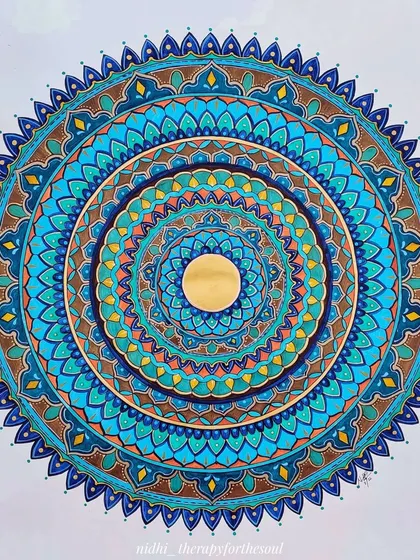 'Peacock in the Desert Rain 2.0', a custom mandala featuring a beautiful palette of blues, teals, and earthy browns, with a shining gold center.